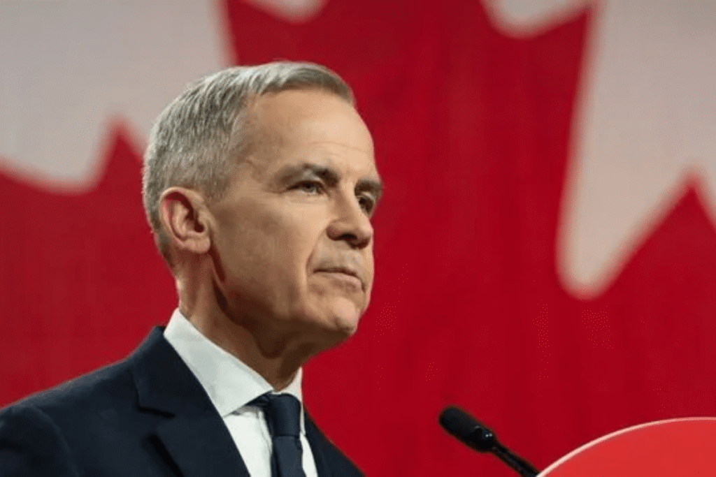 Mark Carney delivers a speech in front of a Canadian flag during the 2025 federal election.